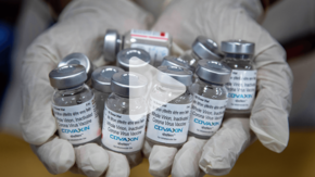 bottles of vaccine with play arrow overlay