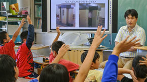 Tsubokura speaks to a classroom of young children.