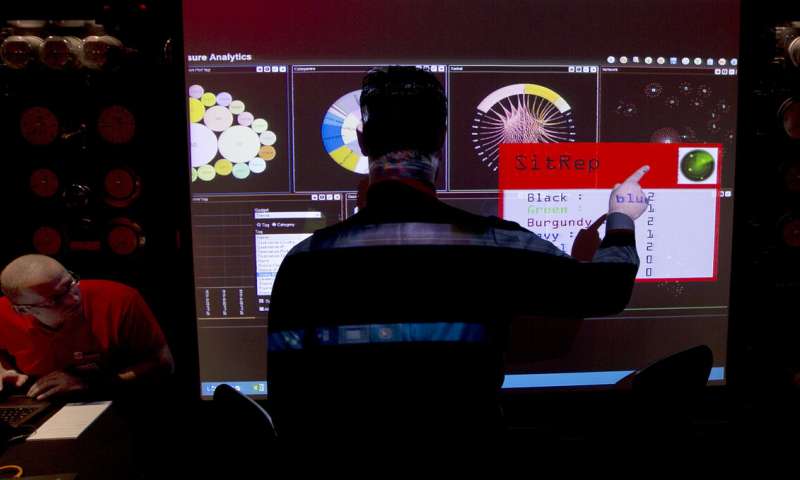In this March 14, 2014, file photo, a representative of GCHQ points to a screen showing all the teams progress in completing the task during a mock cyberattack scenario with teams of amateur computer experts taking part and trying to fight this simulated attack in London. Computer systems across a major hospital chain operating in the U.S. and Britain were down Monday, Sept. 28, 2020, due to what the company termed an unspecified technology "security issue." Universal Health Services Inc., which operates more than 400 hospitals and other clinical care facilities, said in a short statement p osted to its website Monday that its network was offline and doctors and nurses were resorting to "back-up processes" including paper records. (AP Photo/Alastair Grant, File) Cyberattack hobbles major hospital chain's US facilities