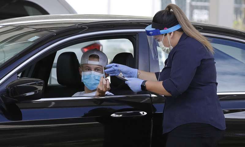 A healthcare worker takes information from a person at a Covid-19 testing center on Tuesday, July 21, 2020, in Pleasanton, Calif. (AP Photo/Ben Margot) World virus cases top 15M; US labs buckle amid testing surge