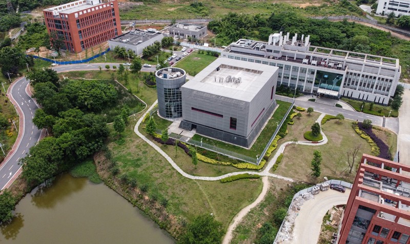 Aerial shot of a complex of modern academic buildings surrounded by trees and grass.