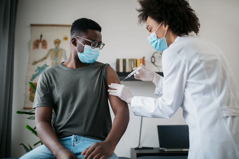 Young man getting a vaccine from his doctor