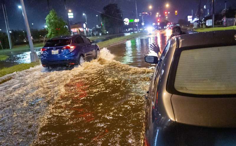 Lamont Pepp, right, waves to a passing motorist to slow down after Pepp's car stalled in high water on Gause Boulevard in Slidell late Friday, June 18, 2021, as a tropical disturbance neared the Louisiana shore. Tropical Storm Claudette has formed Saturday morning along the U.S. Gulf Coast, bringing heavy rains and flooding to coastal states including Louisiana, Mississippi and Alabama. Credit: Scott Threlkeld/The Advocate via AP Major damage to Alabama mobile home park amid tropical storm