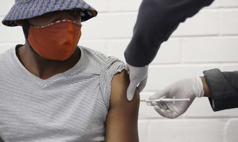In this Wednesday, June 24, 2020 file photo, a volunteer receives a COVID-19 test vaccine injection developed at the University of Oxford in Britain, at the Chris Hani Baragwanath hospital in Soweto, Johannesburg, South Africa. People on six continents are testing experimental shots as the race for a COVID-19 vaccine enters a defining summer, with even bigger studies poised to prove if any leading candidate really works - and possibly offer the public a reality check. (AP Photo/Siphiwe Sibeko) Summer may decide fate of leading shots in vaccine race