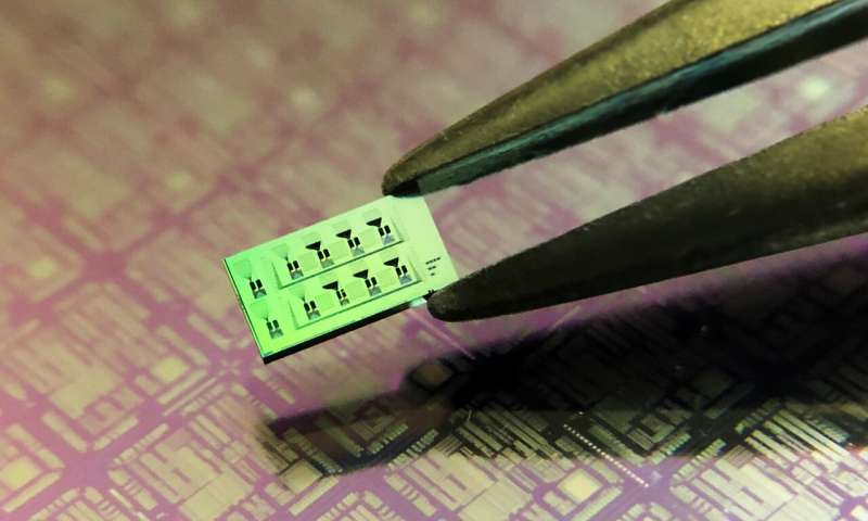 Silicon chip (approx. 3 mm x 6 mm) with multiple detectors. The fine black engravings on the surface of the chip are the photonics circuits interconnecting the detectors (not visible with bare eyes). In the background a larger scale photonics circuit on a silicon wafer. Credit: Helmholtz Zentrum Muenchen / Roman Shnaiderman Researchers have developed the world's smallest ultrasound detector