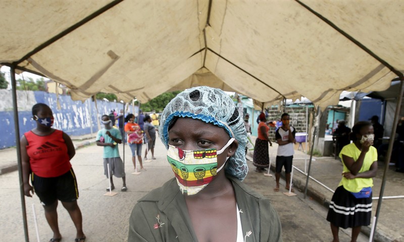 People stand in line waiting for food rations in Monrovia, Liberia
