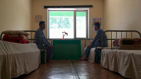 two patients sit in a dormitory room.