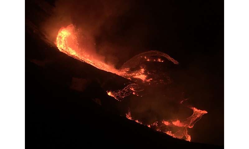 In this photo provided by the U.S. Geological Survey, lava flows within the Halema'uma'u crater of the Kilauea volcano Sunday, Dec. 20, 2020. The Kilauea volcano on Hawaii's Big Island has erupted, the U.S. Geological Survey said. (U.S. Geological Survey via AP) Volcano erupts on Hawaii's Big Island, draws crowds to park