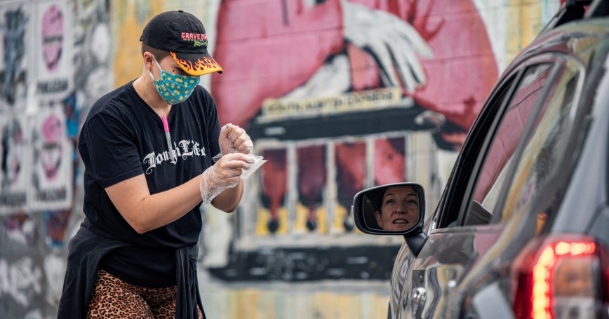 An employee of a pizza restaurant talks to a customer in Austin, Texas, June 28, 2020, photo by Sergio Flores/Reuters