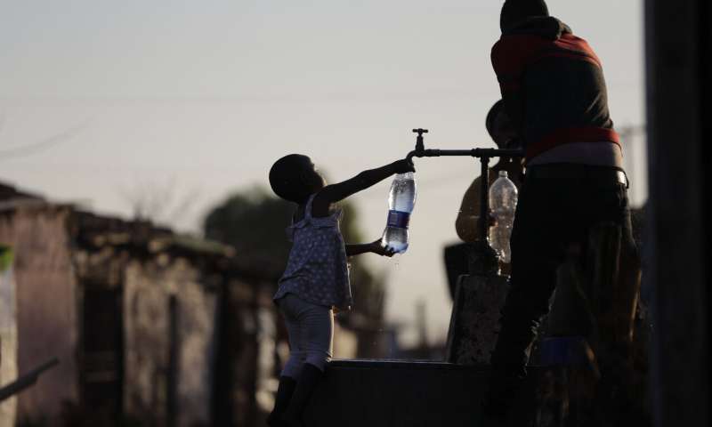 A child fills a bottle with water at a communal tap in the Katlehong Township near Johannesburg, Tuesday, Sept. 8, 2020. Official statistics show that South Africa's economy has sunk deeper into recession, with its gross domestic product for the second quarter of 2020 plummeting by 51%, largely as a result of COVID-19 and the country's strict lockdown. (APPhoto/Themba Hadebe) South Africa says 12 million 'probably' had coronavirus