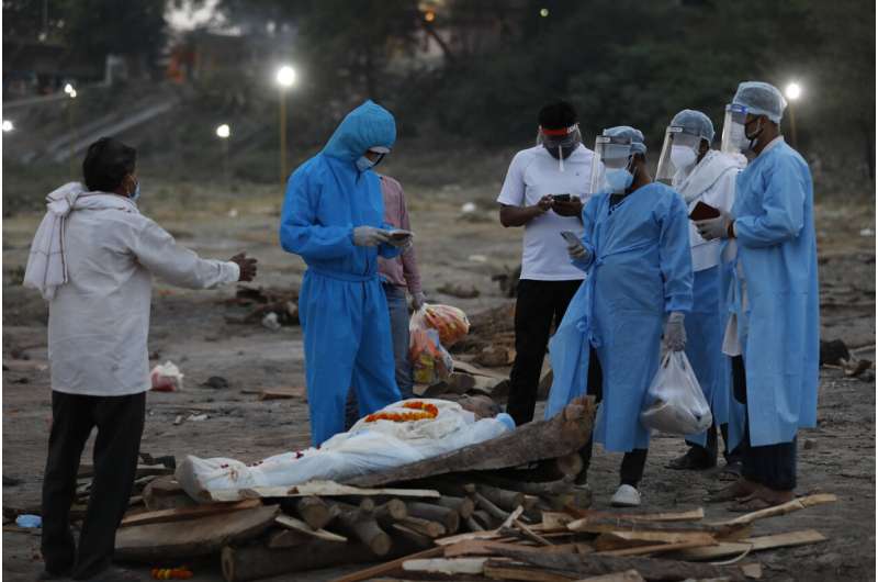 Family members pay last respect to their relative Rajendra Prasad Mishra, a 62-year-old man who has lost his life from coronavirus infection before cremation at River Ganges at Phaphamau in Prayagraj, India, Saturday, May 8, 2021. (AP Photo/Rajesh Kumar Singh) As cases grow, India's vaccination campaign falters