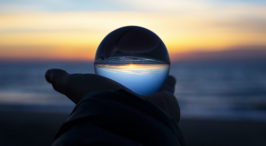Flying cars - hand holding sphere reflecting water