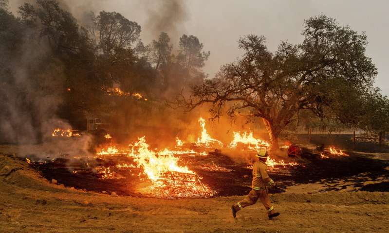 A firefighter runs past flames while battling the Glass Fire in a Calistoga, Calif., vineyard Thursday, Oct. 1, 2020. (AP Photo/Noah Berger) Better weather won't keep California from grim fire landmark