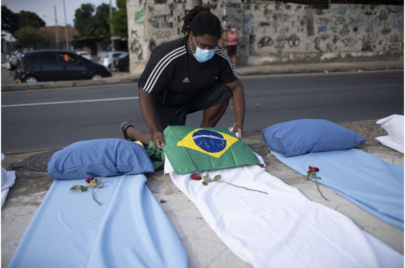 A demonstrator places a Brazil national flag on a mattress symbolizing COVID-19 victims, during a protest against the Government's handling of the COVID-19 pandemic, organized by the Rio de Paz NGO, in front of the Ronaldo Gazolla hospital in Rio de Janeiro, Brazil, Wednesday, March 24, 2021. (AP Photo/Silvia Izquierdo) Brazil becomes 2nd nation to top 300,000 COVID-19 deaths