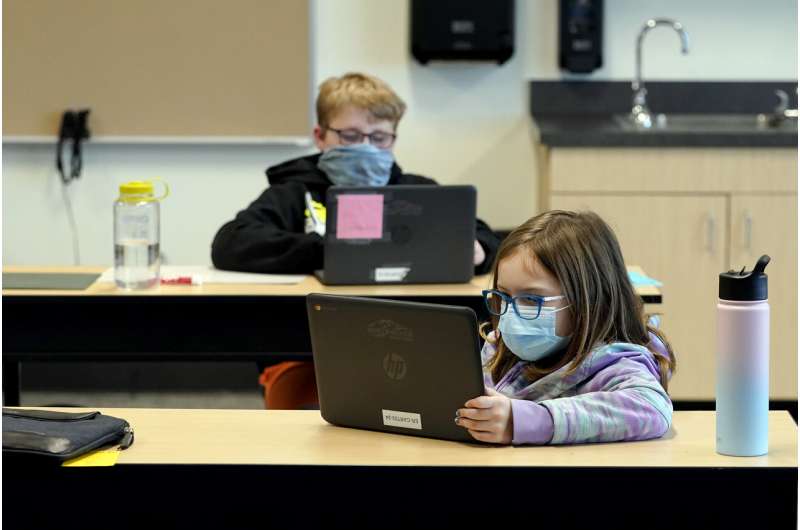 In this Feb. 2, 2021, file photo, students wear masks as they work in a fourth-grade classroom, at Elk Ridge Elementary School in Buckley, Wash. Amid mounting tensions about school reopening, the Centers for Disease Control and Prevention planned to release long-awaited guidance Friday, Feb. 12, 2021, on what measures are needed to get children back into the classroom during the pandemic. (AP Photo/Ted S. Warren, File) CDC: Strong evidence in-person schooling can be done safely