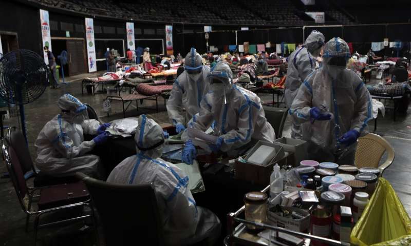 In this Wednesday, July 8, 2020, file photo, doctors and nurses work at a COVID-19 isolation center in Mumbai, India. In just three weeks, India's confirmed cases shot up from the world's sixth to the third-worst hit country by the coronavirus pandemic, according to a tally by Johns Hopkins University. India's fragile health system was bolstered during stringent monthslong lockdown but could still be overwhelmed by an exponential rise in infections. (AP Photo/Rajanish Kakade, File) Why India cases are rising to multiple peaks