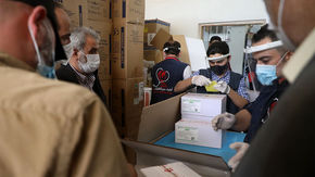 Staff of the Physicians Across Continents group unload a batch of vaccines