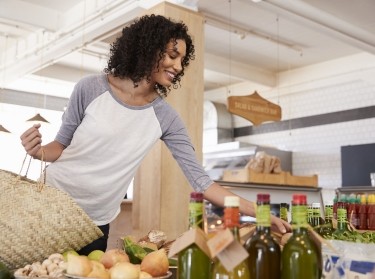Woman shopping for organic produce in delicatessen, photo by Monkey Business Images/Adobe Stock