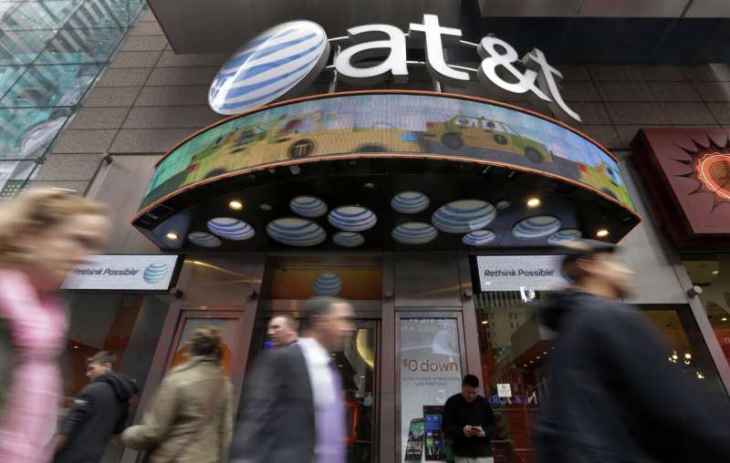 In this Oct. 21, 2014 file photo, people pass an AT&T store in New York's Times Square. AT&T will combine its media operations that include CNN HBO, TNT and TBS in a $43 billion deal with Discovery, the owner of lifestyle networks including the Food Network and HGTV. The deal announced Monday, May 17, 2021, would create a separate media company as households increasingly abandon cable and satellite TV, looking instead at Netflix, Amazon Prime Video, Facebook, TikTok and YouTube. (AP Photo/Richard Drew, File) AT&T will merge WarnerMedia operations with rival Discovery