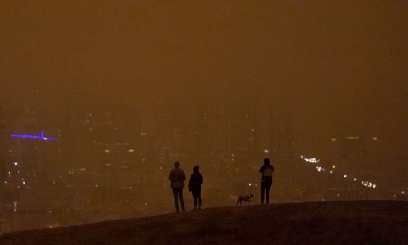 People look toward the skyline obscured by wildfire smoke in daytime from Kite Hill Open Space in San Francisco, Wednesday, Sept. 9, 2020. (AP Photo/Jeff Chiu) Massive smoke clouds, thick air darken Western US skies
