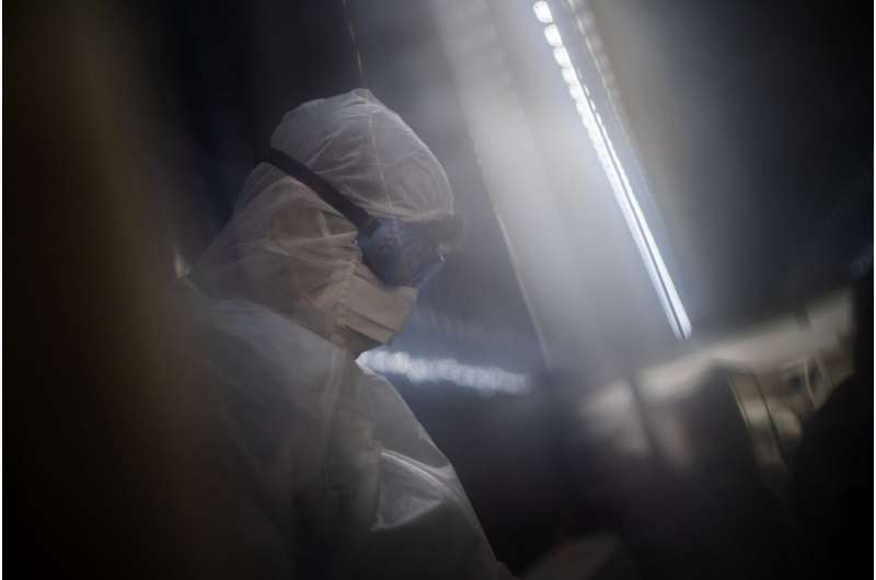 In this file photo dated Tuesday, Feb. 2, 2021, a mortuary employee wearing full PPE checks coffins containing the remains of COVID-19 victims in a refrigerated container in Johannesburg. The World Health Organization Monday Feb. 15, 2021, granted an emergency authorization to the coronavirus vaccine made by AstraZeneca, a move that should allow its partners to ship millions of doses to countries worldwide as part of a U.N.-backed program to stop the pandemic.(AP Photo/Jerome Delay) UN vaccine plan for poor countries nears rollout