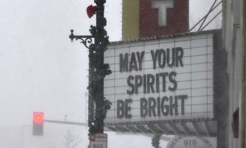 Snow swirls around the marquee of the Paramount Theatre featuring a holiday message in the afternoon Wednesday, Dec. 23, 2020, in St. Cloud, Minn. Blowing and drifting snow made travel hazardous in Central Minnesota Wednesday. (Dave Schwarz/St. Cloud Times via AP) Winter storm in Dakotas, Minnesota make travel frightful