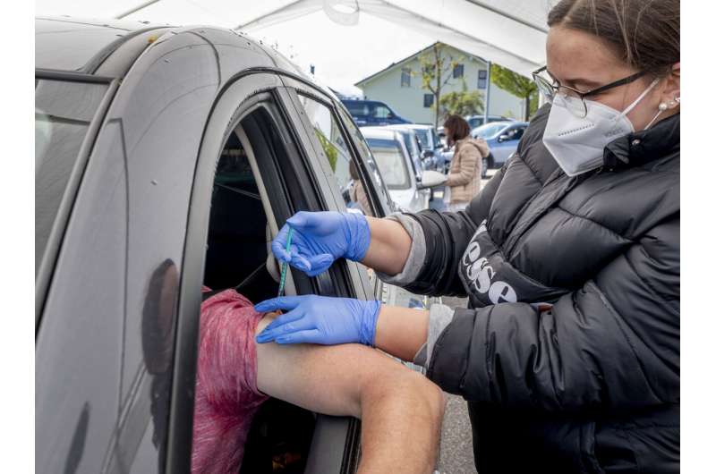 A man sits in his car as he is vaccinated with AstraZeneca in a tent on the parking lot of a supermarket in Pforzheim, southern Germany, Wednesday, May 5, 2021. A doctor who could not get rid of her AstraZeneca vaccine in her doctor's office decided to offer some 250 doses in drive-in location at the supermarket. (AP Photo/Michael Probst) Germany makes AstraZeneca vaccine available to all adults
