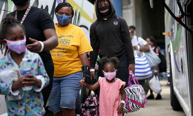 Shawn Nelson, 7, right, and Asia Nelson, 6, left, board a bus to evacuate Lake Charles, La., Wednesday, Aug. 26, 2020, ahead of Hurricane Laura. (AP Photo/Gerald Herbert) Laura strengthens into 'extremely dangerous' Category 4