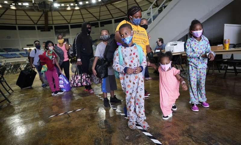 Victoria Nelson with her children Autum Nelson, 2, Shawn Nelson, 7, and Asia Nelson, 6, line up to board a bus to evacuate Lake Charles, La., Wednesday, Aug. 26, 2020, ahead of Hurricane Laura. (AP Photo/Gerald Herbert) Laura strengthens into 'extremely dangerous' Category 4