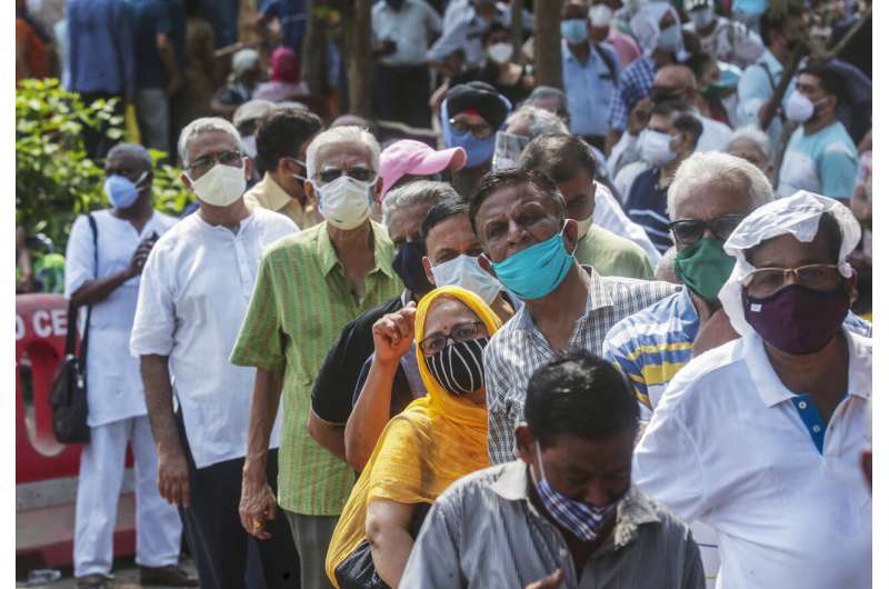 In this April 26, 2021, file photo, people queue up for coronavirus vaccine in Mumbai, India. The disparities of the coronavirus pandemic were already stark in India, where access to health care is as stratified and unequal as other parts of its society. Now, the divide along the lines of wealth and technology are further widening that chasm, and many people are falling through the gaps as vaccines remain inaccessible to millions. Credit: AP Photo/Rafiq Maqbool, File Vaccine inequality in India sends many falling through gaps