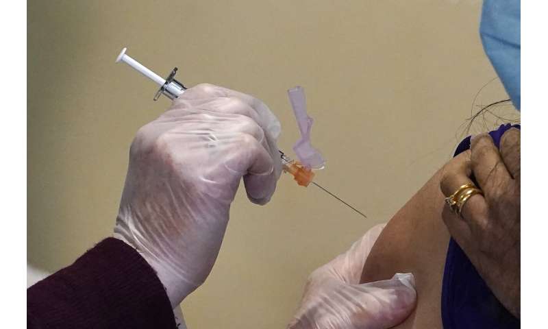 Registered nurse Allison Miller administers one of the first Pfizer-BioNTech COVID-19 vaccinations at UW Medicine Tuesday, Dec. 15, 2020, in Seattle. Several states have been told to expect far fewer doses of Pfizer's COVID-19 vaccine in its second week of distribution, but the reason remains a mystery as the company said Thursday, Dec. 17, that its production expectations remain unchanged.(AP Photo/Elaine Thompson, File) Some states say Pfizer vaccine allotments cut for next week