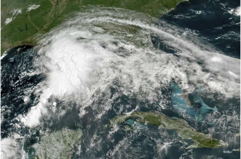This GOES-16 GeoColor satellite image taken Friday, June 18, 2021, at 11 a.m. EDT, and provided by NOAA, shows a tropical weather system in the Gulf of Mexico. Officials ordered a floodgate and locks system closed in southeast Louisiana and readied sandbags in Mississippi and Alabama as a broad, disorganized tropical weather system began spinning bands of rain and brisk wind across the northern Gulf of Mexico coast Friday. Credit: NOAA via AP Major damage to Alabama mobile home park amid tropical storm