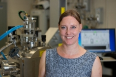 MIT Associate Professor Jennifer Rupp stands in front of a pulsed laser deposition chamber, in which her team developed a new lithium garnet electrolyte material with the fastest reported ionic conductivity of its type. The technique produces a thin film about 330 nanometers thick. “Having the lithium electrolyte as a solid-state very fast conductor allows you to dream out loud of anything else you can do with fast lithium motion,” Rupp says. 