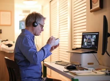 Doug Hassebroek eats breakfast while on a video conference call at his home in Brooklyn, April 24, 2020, photo by Caitlin Ochs/Reuters