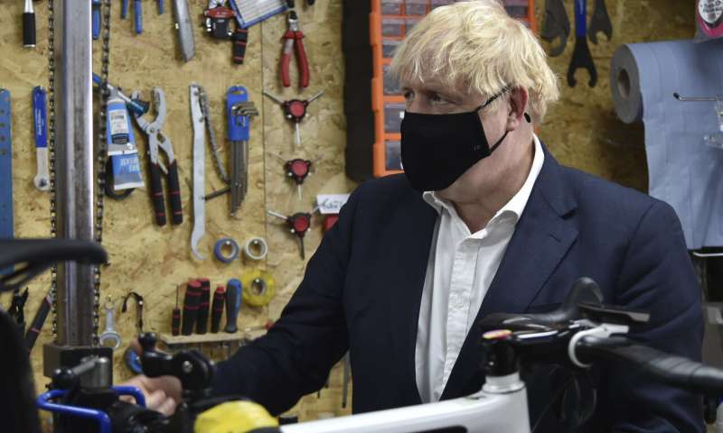 Britain's Prime Minister Boris Johnson talks to the owner of the the Cycle Lounge, Rodney Rouse, a bicycle repair shop Beeston near Nottingham, England, Tuesday, July 28, 2020. The government is launching a new cycling intuitive to help get people fitter. (AP Photo/Rui Vieira, Pool) Stats: England had Europe's highest extra deaths in pandemic